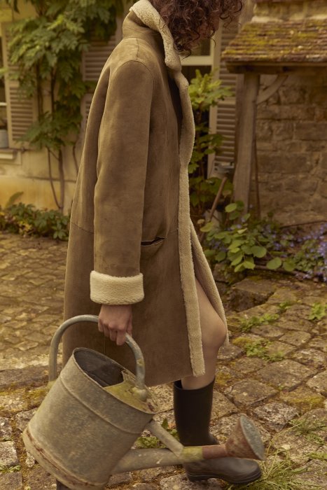 Un manteau long avec peau retournée Un manteau long avec peau retournée