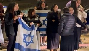 Des Israéliens applaudissent en attendant le convoi des otages libérés dans le sud d'Israël