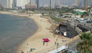 Des baigneurs courent se mettre à l'abri alors que des sirènes retentissent à Tel-Aviv