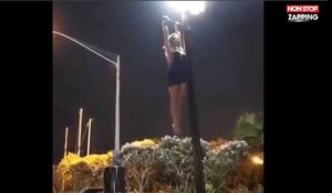 Une femme sexy offre un époustouflant numéro d'acrobatie sur un lampadaire (vidéo)