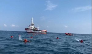 Des migrants sautent d'un bateau de sauvetage au large de l'Italie