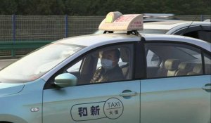 Coronavirus: des voitures à un point de contrôle routier à Wuhan alors que les autorités lèvent l'interdiction de sortie