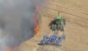 Un agriculteur fait un coupe-feu en tracteur