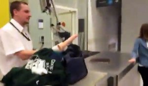 Un homme se fait fouiller ses bagages à l'aéroport