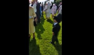 Un petit garçon serre la main de la reine Elisabeth, au mépris du protocole