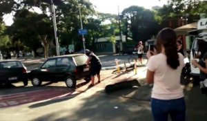 Un homme costaud soulève et bouge une voiture mal garée