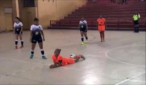 Une joueuse de Football Indoor met un grand coup de pied dans la tête de son adversaire au sol