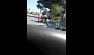 Elle tente de démarrer un scooter avec la béquille