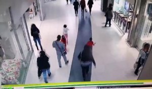 Un gars plaque au sol un voleur dans un centre commercial