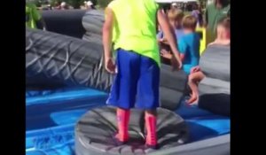 Un enfant se fait défoncer par un boudin gonflable dans un jeu d'obstacles