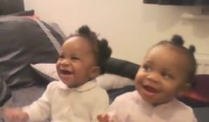 Gêmeas dançando e sorrindo enquanto a mãe canta