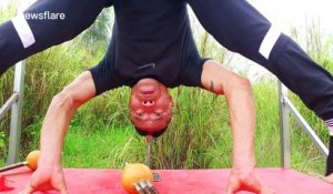 Man does a head stand on a steel pipe and plays the flute