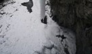 Un homme fait une grosse chute en escaladant une cascade gelée