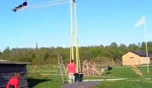 Un homme essaye de faire un tour complet sur une balançoire géante