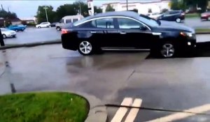 Cette femme s'echappe de sa voiture alors qu'elle se fait engloutir en pleine route