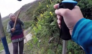 Une femme poursuit des touristes dans la montagne népalaise