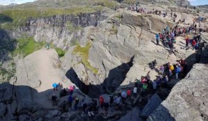 Des randonneurs font la queue pour une photo sur un rocher