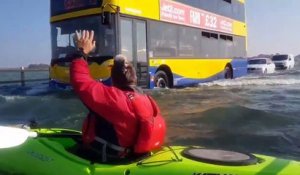 Il fait du kayak sur une route inondée alors que des voitures roulent encore - Mersea Island, Essex