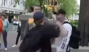 Un garde du corps arrête le coup de poing d’un manifestant avec la main
