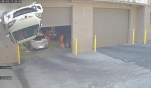 Une voiture atterrit sur le toit devant un garage