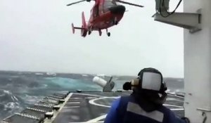 Un hélicoptère tente d'atterrir sur un bateau en pleine tempête