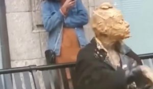 Une femme se recouvre le visage avec du beurre de cacahuète en pleine rue