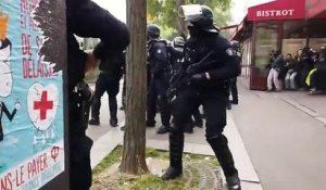 Un policier renvoie un pavé sur des manifestants (1er mai 2019)
