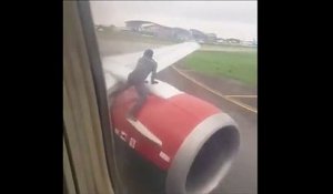 Il grimpe sur l'aile d’un avion juste avant le décollage