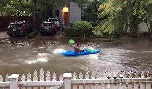 Il fait du kayak dans une rue inondée