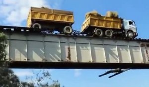 Ce camion est en équilibre sur les rails d'un pont ferroviaire... risqué