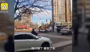 Un lampadaire tombe d'un coup sur une voiture en pleine route !