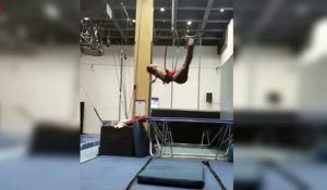 Acrobate accrochée par le t-shirt et par les cheveux