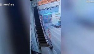 Un enfant reste suspendu à la rampe de cet escalator...