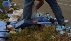 Des centaines de boîtes de thon échouées sur la route après un incident, des passants se pressent pour en ramasser