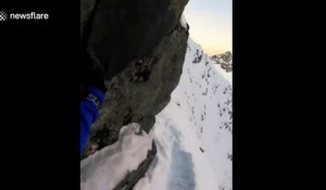 Un alpiniste marche sur la crête d'une montagne et c'est vertigineux