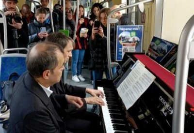 Deux musiciens installent leur piano dans un tramway pour un concert de musique classique