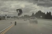 Percutée par un pneu, une voiture se retrouve propulsée dans les airs sur une autoroute américaine