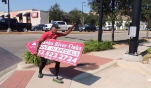 Champion de "Sign Spinning", il fait tourner un panneau publicitaire dans la rue.