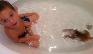 Un petit garçon prend son bain avec un bébé singe