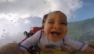 Un bébé fait du surf et il adore ça!