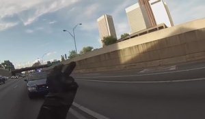Un motard fait un wheeling devant une voiture de police et sème les policiers