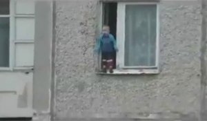 Un enfant russe joue sur le bord d'une fenêtre au 8ème étage