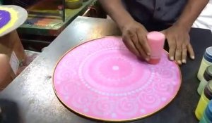 Un artiste de rue réalise une superbe peinture éphémère rangoli