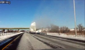 Un camion couvert de neige passe sous un camion et provoque une explosion de poudreuse sur l'autoroute