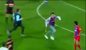 Un footballeur met un coup de pied à un supporter qui s'incruste sur le terrain en plein match