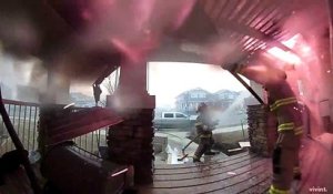 Des pompiers luttant contre l'incendie d'une maison filmés par une caméra de surveillance
