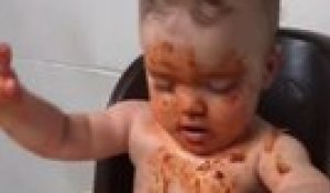 Un bebe essaie de rester éveillé pour manger ses spaghetti