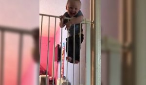 Un bébé escalade une double barrière de sécurité