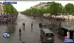 Macron redescend les Champs-Élysées, saluant la foule à travers le toit de sa voiture
