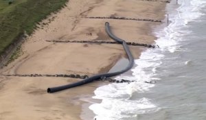 De gigantesques tuyaux s'échouent sur une plage et intriguent les promeneurs